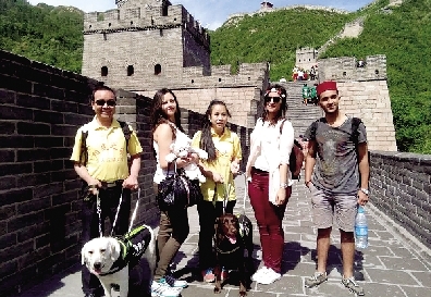 兩位盲人和導(dǎo)盲犬在長(zhǎng)城上與外國(guó)游客合影 受訪(fǎng)者供圖