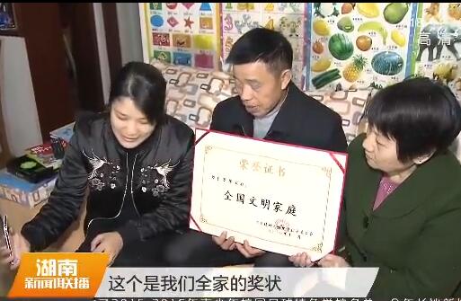羅華用視頻方式向丈夫譚輝展示獲獎證書
